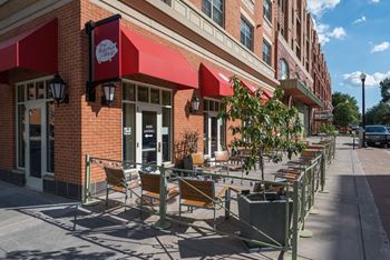 A row of tables and chairs outside of a building